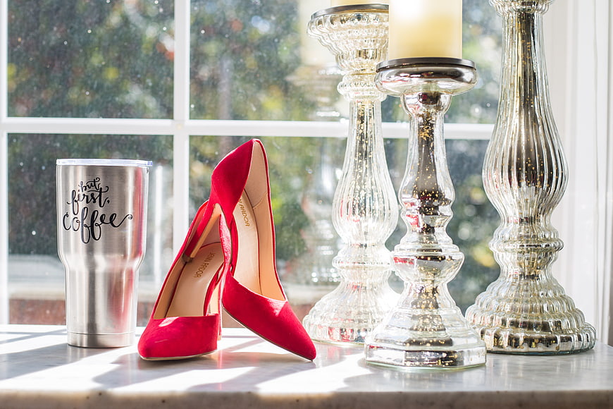 Red Stiletto Heels and Coffee Tumbler on Marble Windowsill