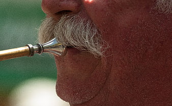 Close-up of man playing trumpet with mustache