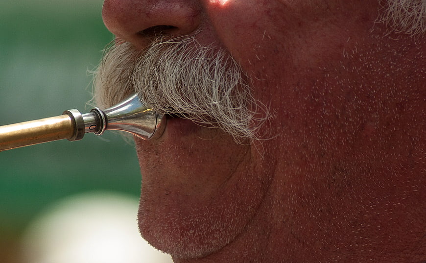 Close-up of man playing trumpet with mustache