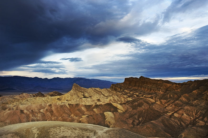 Dramatic desert landscape with eroded mountains and stormy sky