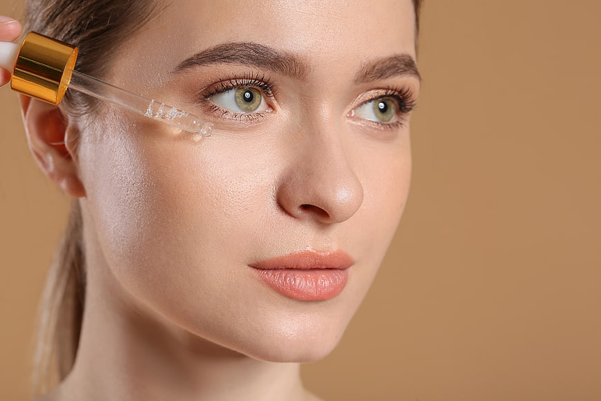 Woman Applying Eye Serum with Dropper
