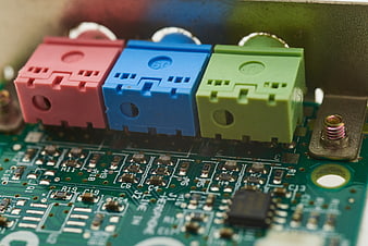 Close-up of colorful electrical connectors on a green circuit board