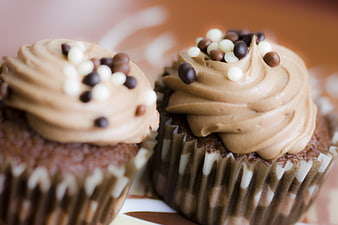 Close-up of two chocolate cupcakes with mocha frosting and sprinkles