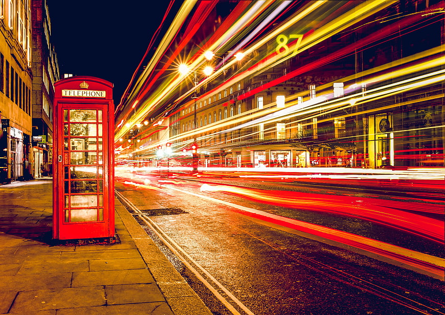 Red telephone box with long exposure light trails at night