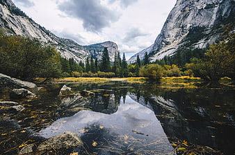 Autumn landscape with mountain reflection in calm river water