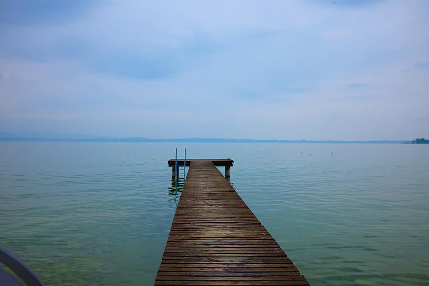 Wooden pier extending into calm blue lake water