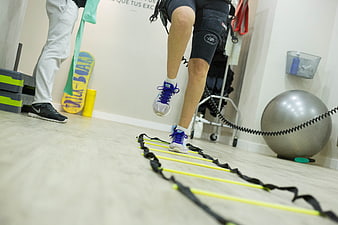 Low angle view of athlete legs using agility ladder in gym
