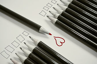 Red pencil drawing heart among black pencils on checklist