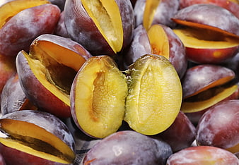 Ripe Purple Plums With Golden Flesh Sliced In Half