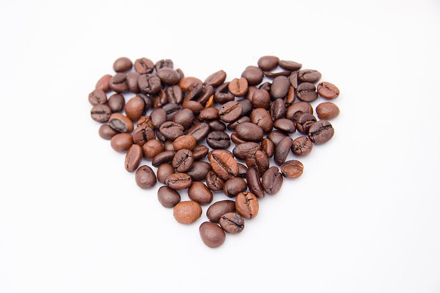 Coffee Beans Arranged In Heart Shape On White Background