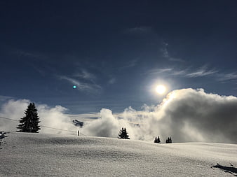 Snowy Mountain Ridge with Clouds and Sun