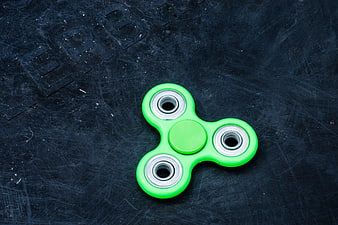 Green Fidget Spinner On Dark Textured Surface