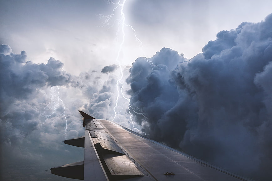 Airplane Wing Flying Through Dramatic Lightning Storm Clouds