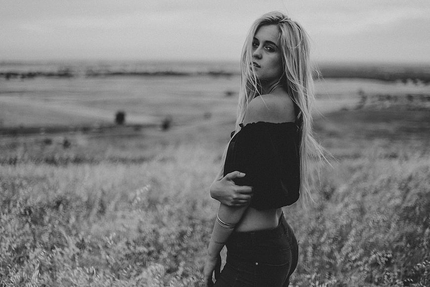 Black and white portrait of a blonde woman in a field