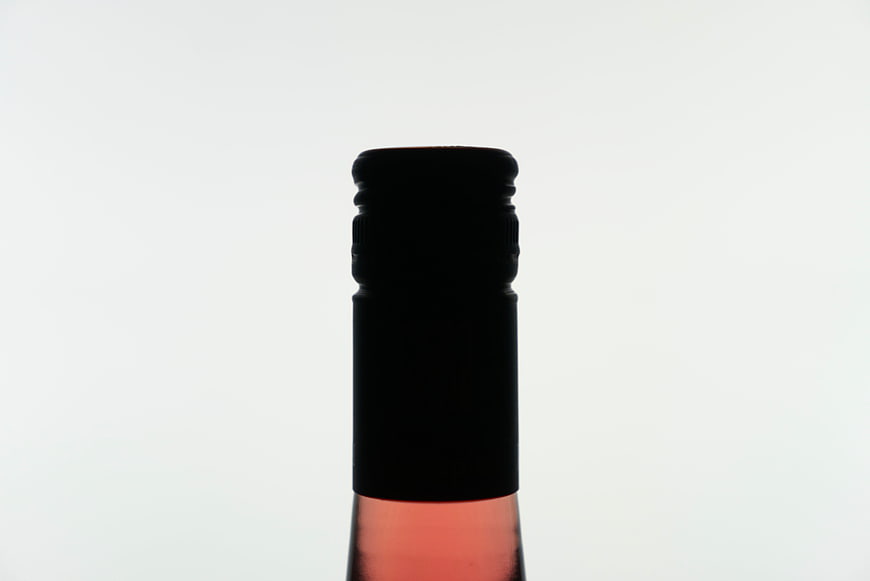 Close-up of a wine bottle neck with black cap