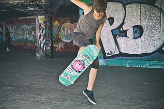 Young Skateboarder Performing Trick in Graffiti Tunnel