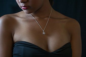 Close-up of woman wearing diamond pendant necklace
