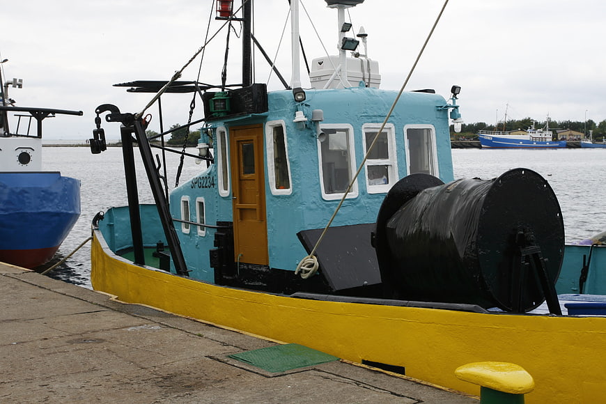 Colorful blue and yellow fishing boat docked at harbor