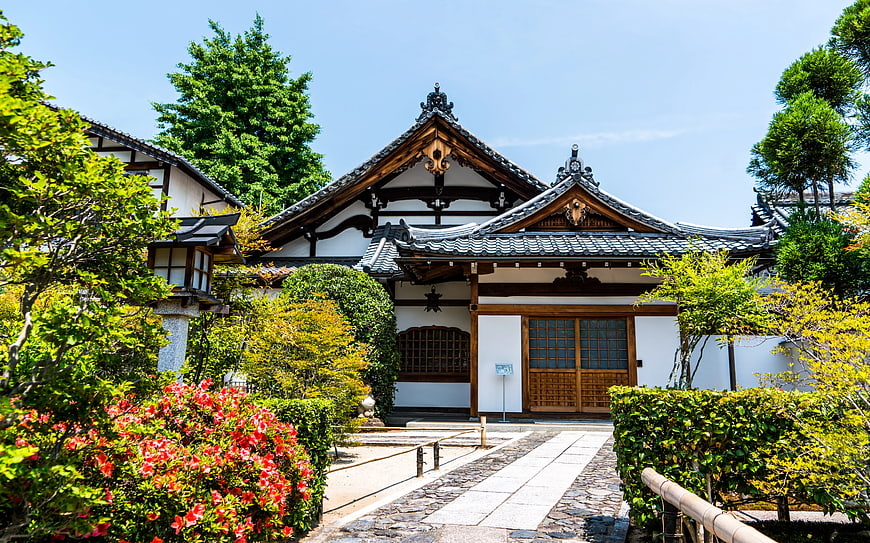 Traditional Japanese Temple with Red Azaleas and Stone Path