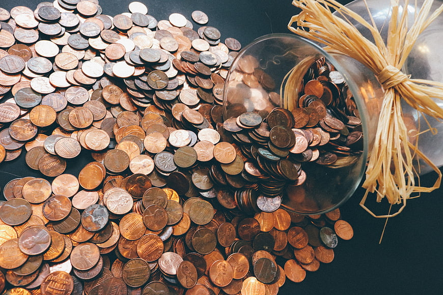 Pile of US Pennies Spilling from Glass Jar