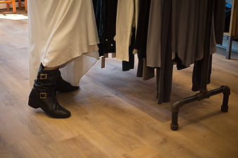 Woman wearing black boots and white skirt in clothing store