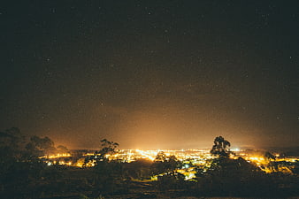 Night Sky Over City Lights with Starry Background