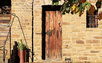 Rustic Old Wooden Door With Lion Knocker On Stone Wall