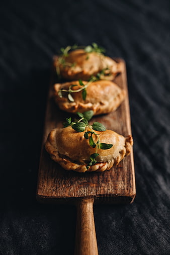 Baked Pierogi on Wooden Board with Herbs
