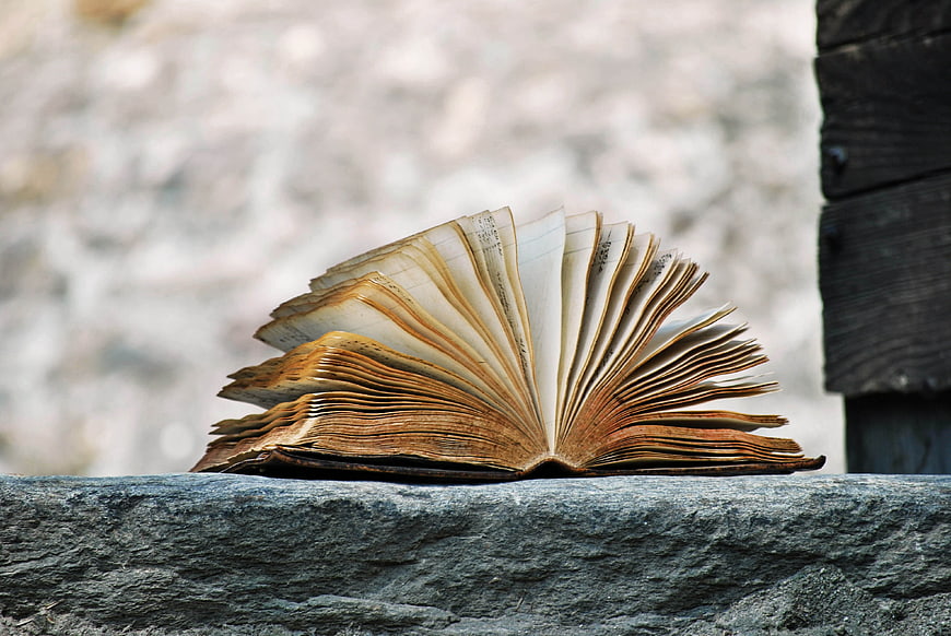 Old Open Book on Stone Wall with Blurred Background