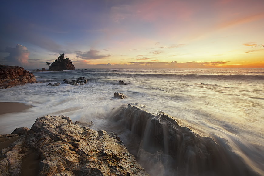 Long Exposure Sunset Ocean Waves Crashing on Rocky Coastline