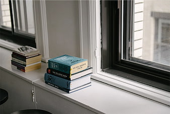 Stack of Books on White Windowsill