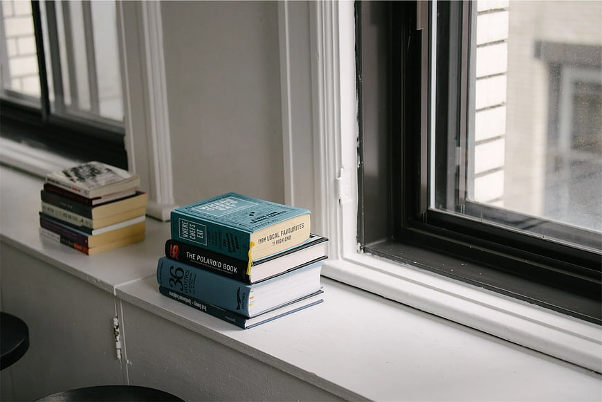 Stack of Books on White Windowsill