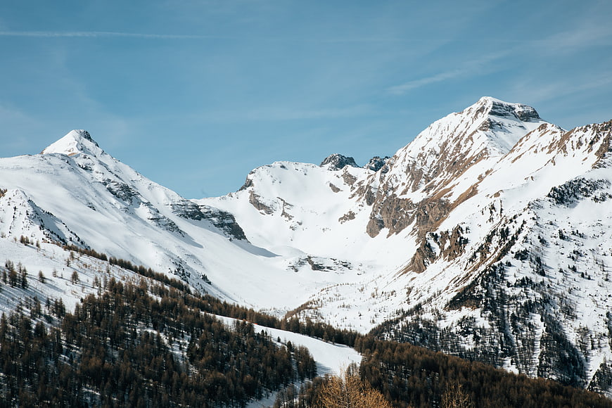 Snowy mountain peaks with pine forest in winter landscape