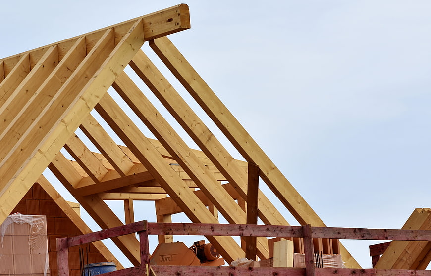 Wooden Roof Truss Construction Against Blue Sky