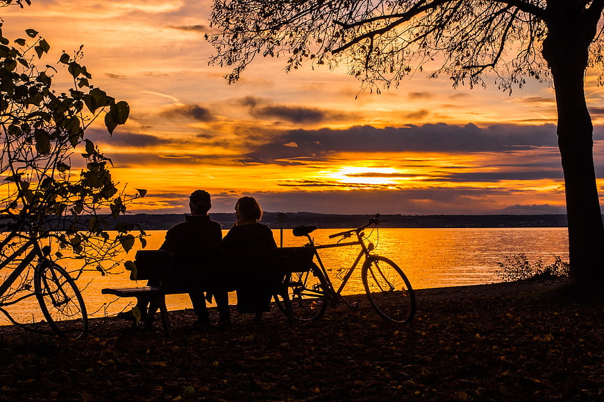 Silhouette of Couple Watching Sunset Over Lake with Bicycles