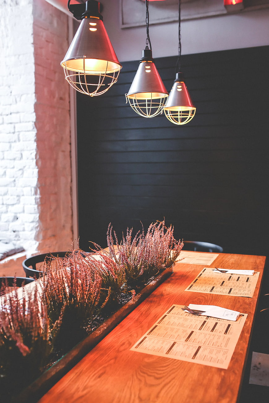 Modern rustic restaurant interior with wooden table and pendant lights