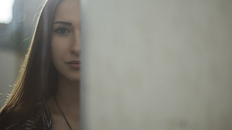 Woman Peeking from Behind Wall with Copyspace