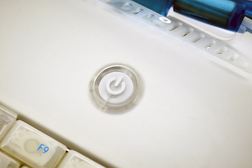 Close-up of white laptop power button with keyboard keys