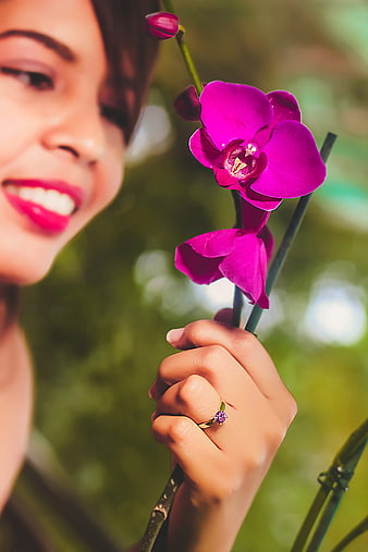 Woman Holding Purple Orchid Flower with Ring