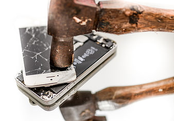 Hammer smashing broken smartphone on white background