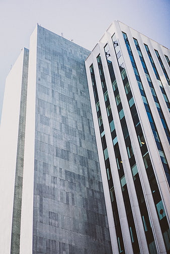Low angle view of modern glass skyscrapers against blue sky