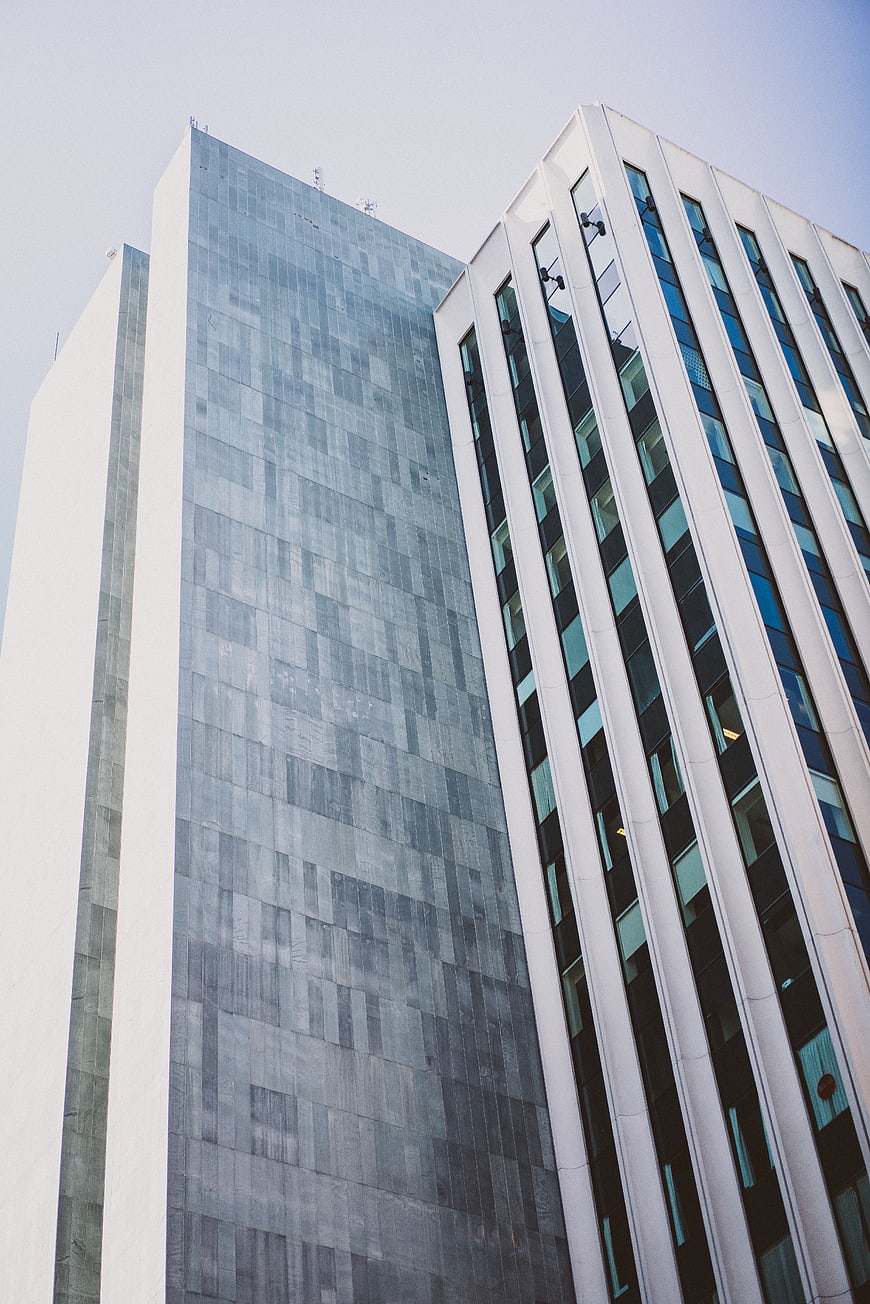 Low angle view of modern glass skyscrapers against blue sky