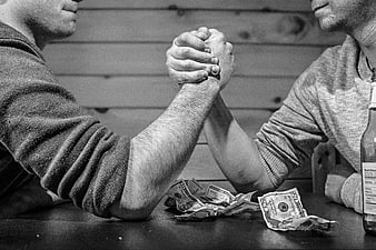 Two Men Arm Wrestling Over Money in Black and White
