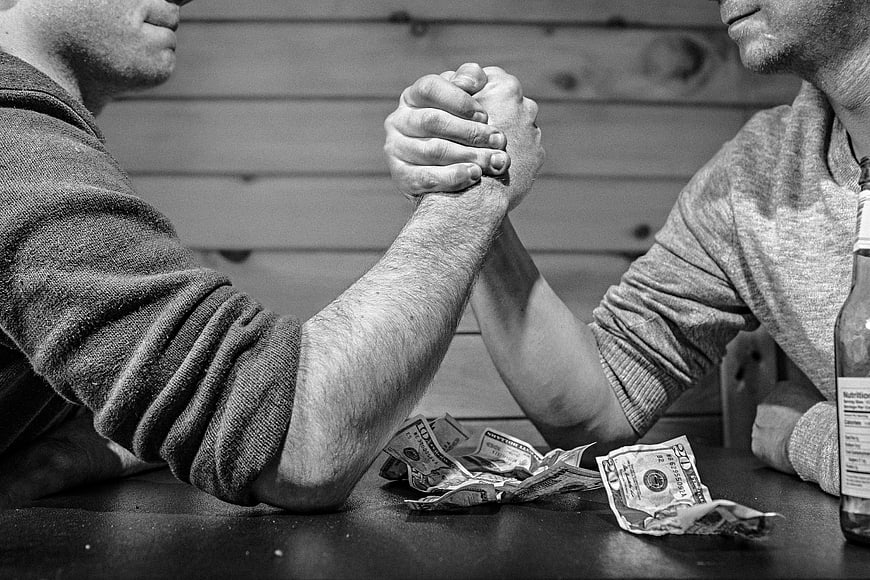 Two Men Arm Wrestling Over Money in Black and White