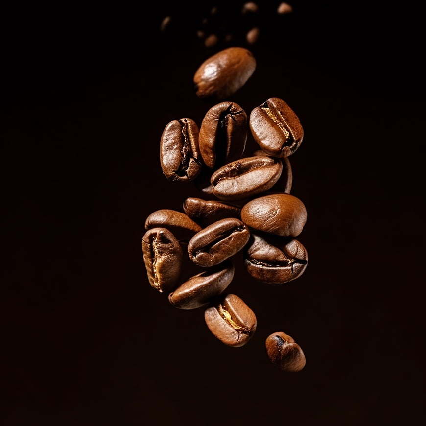 Roasted coffee beans falling against dark background