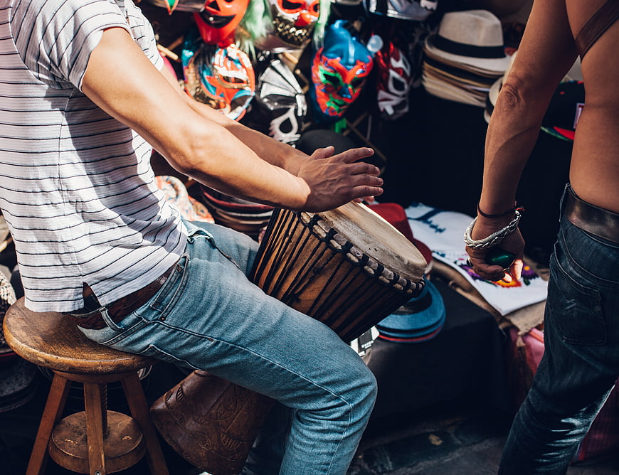 Man Playing Djembe Drum at Outdoor Festival Market