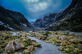Dramatic Mossy Valley Landscape with Mountains and Waterfall