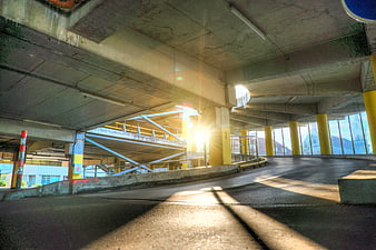 Sunlight streaming through concrete parking garage structure