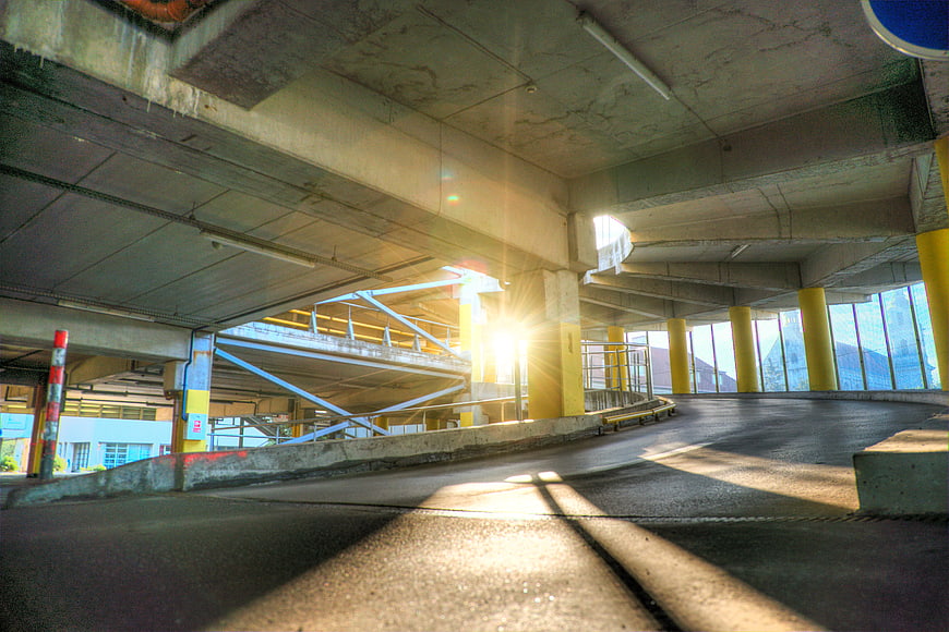 Sunlight streaming through concrete parking garage structure
