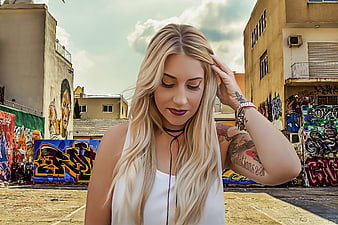 Blonde Tattooed Woman in Urban Graffiti Setting